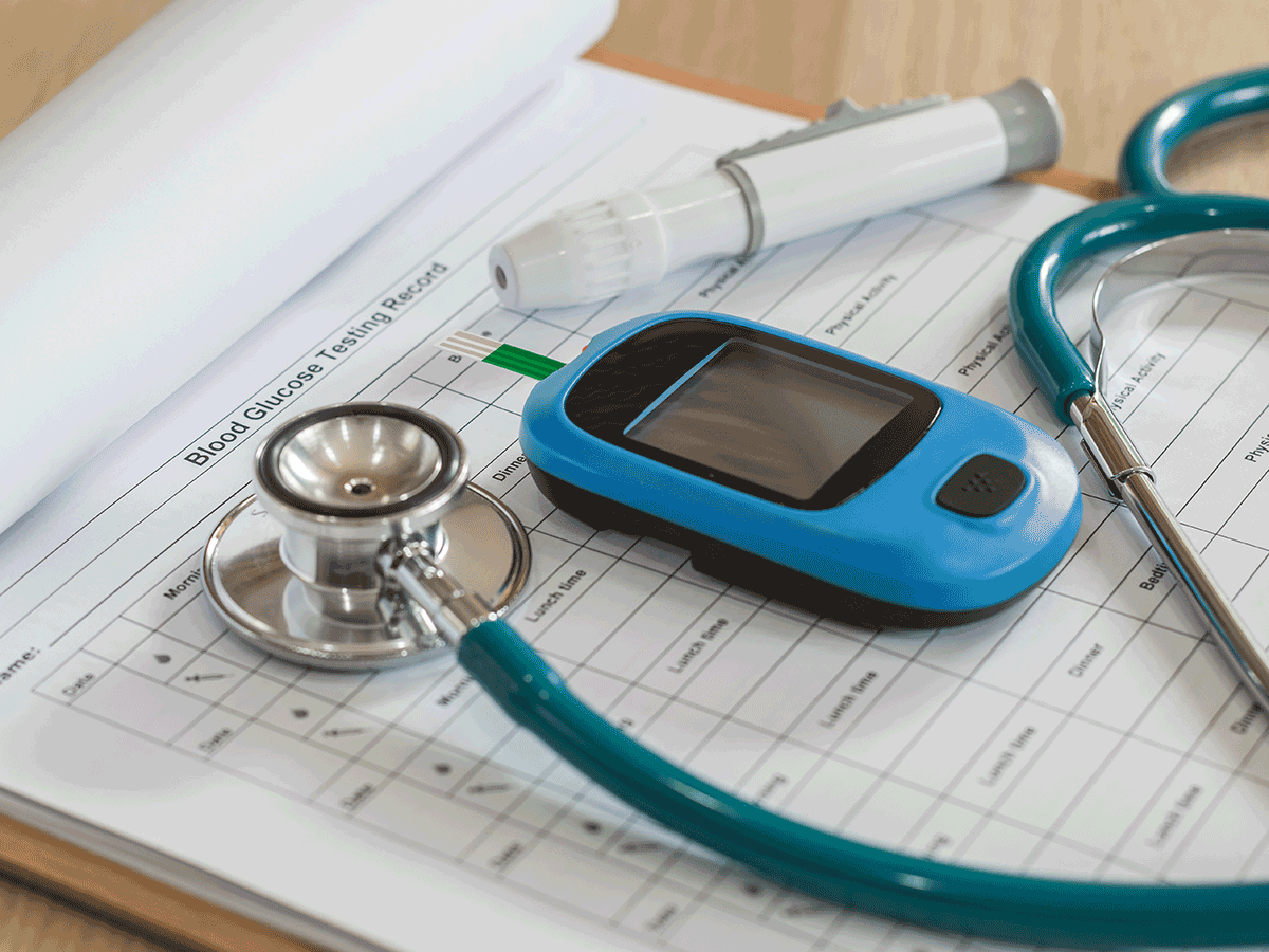 Blood glucose meter, stethoscope and lancing device resting on a blood glucose testing log