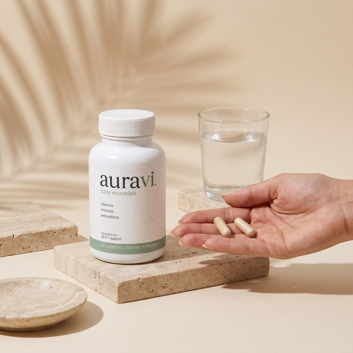 Two Daily Essentials capsules in hand beside the bottle