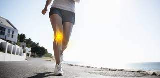 Runner on a sunny seaside path with a glowing highlight over one knee joint