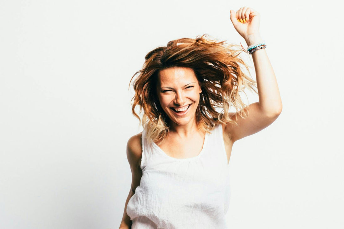 Smiling woman with one arm raised in celebration