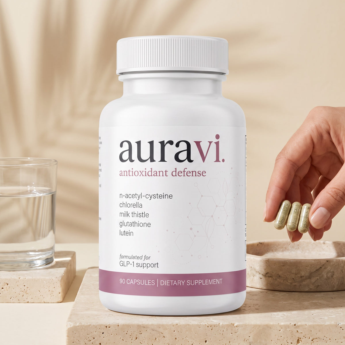 Three Antioxidant Defense capsules in hand beside the bottle