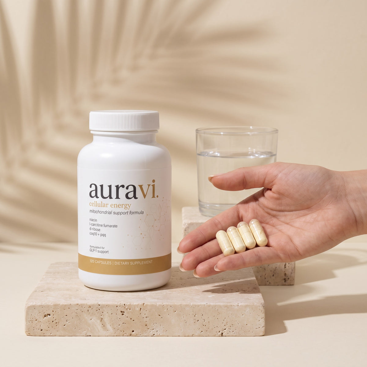 Four Cellular Energy capsules in hand beside the bottle