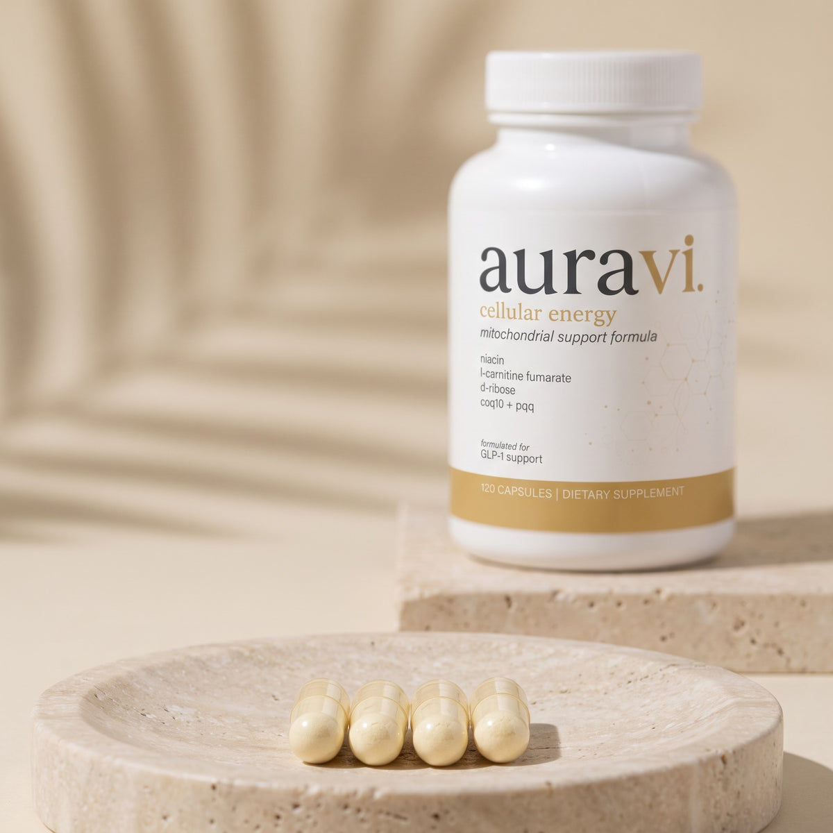 Cellular Energy capsules on a travertine dish beside the bottle