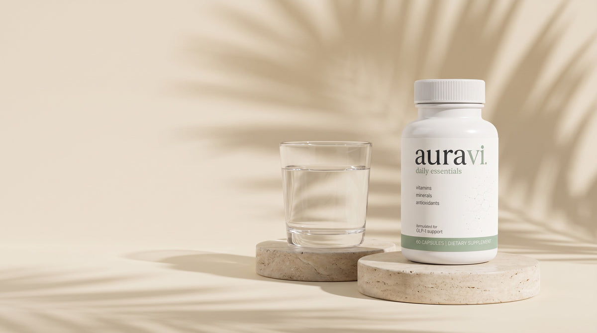 Daily Essentials on a travertine plinth with a glass of water