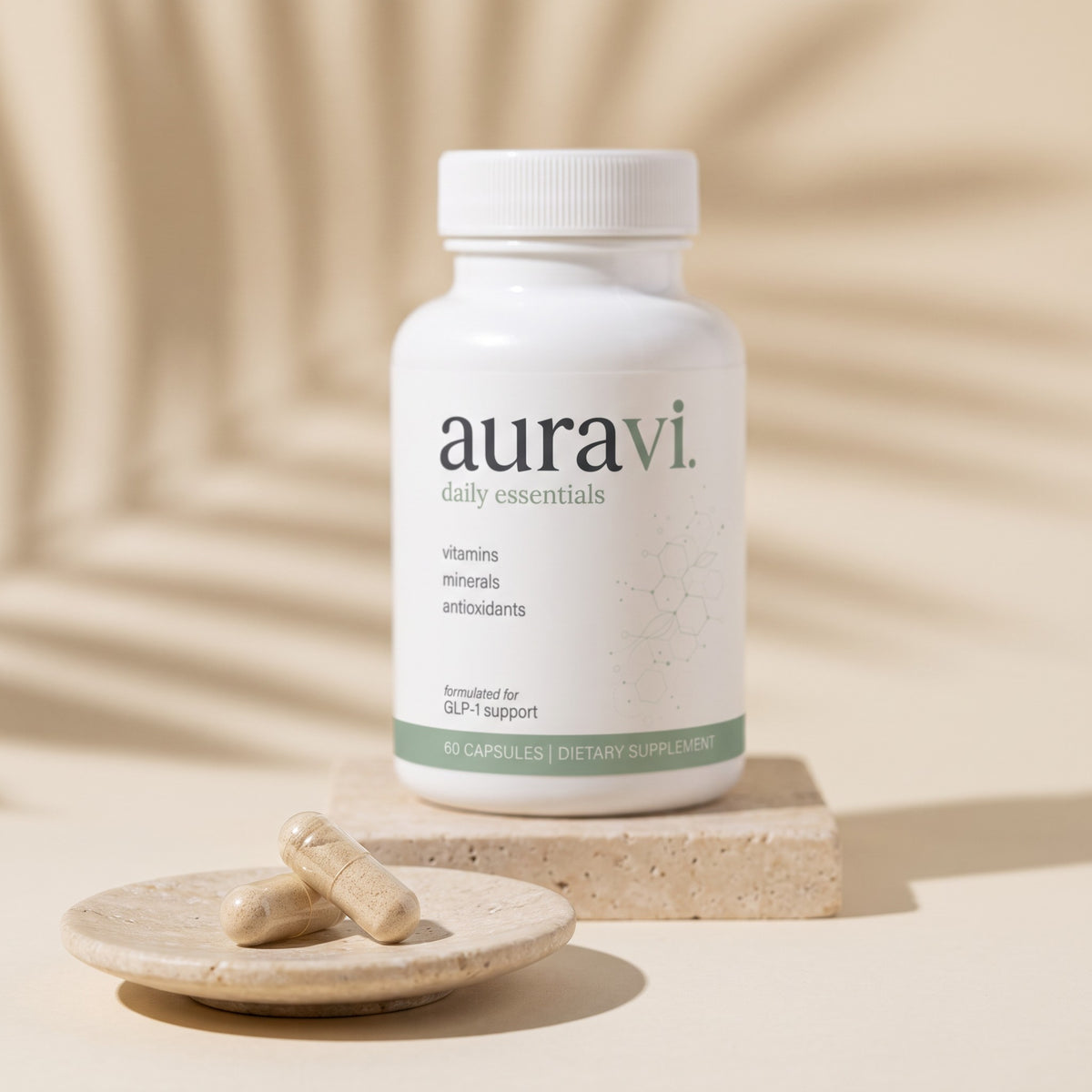 Daily Essentials capsules on a travertine dish beside the bottle