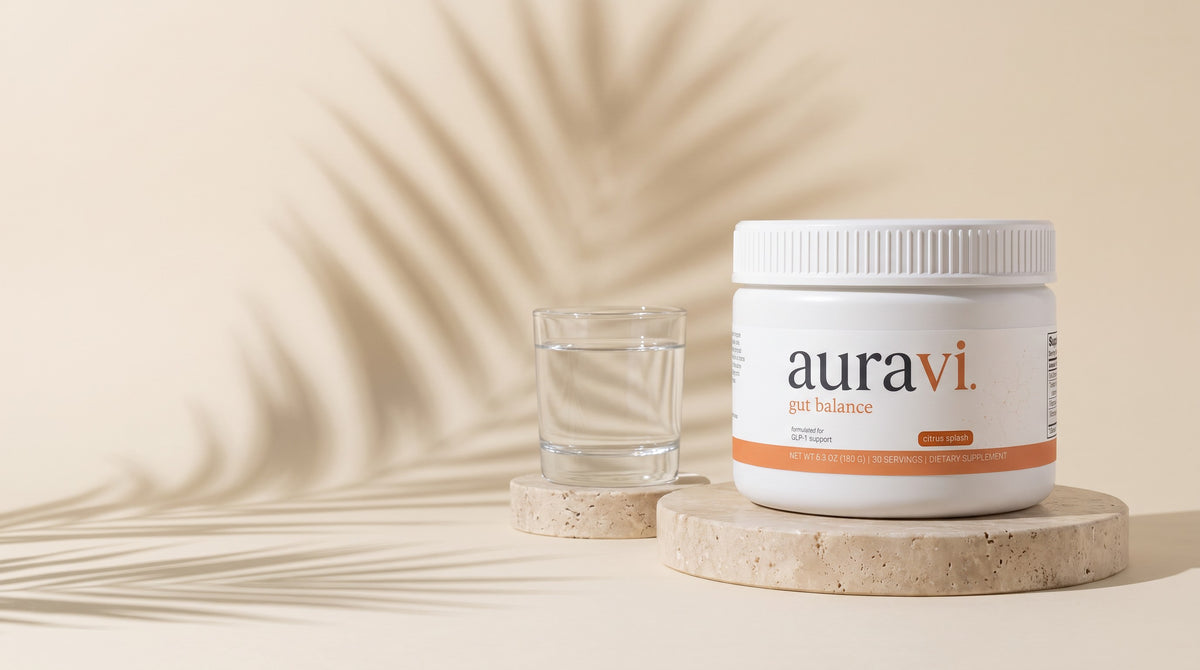 Gut Balance on a travertine plinth with a glass of water