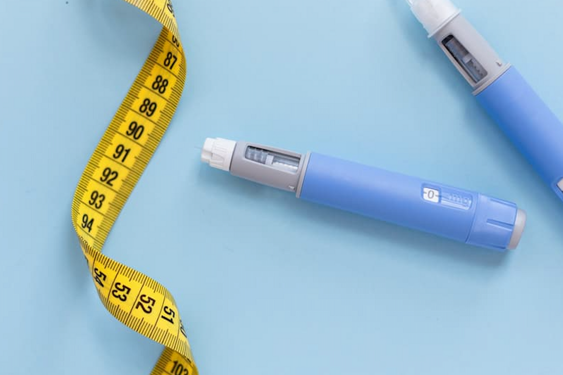 GLP-1 injection pens beside a yellow measuring tape